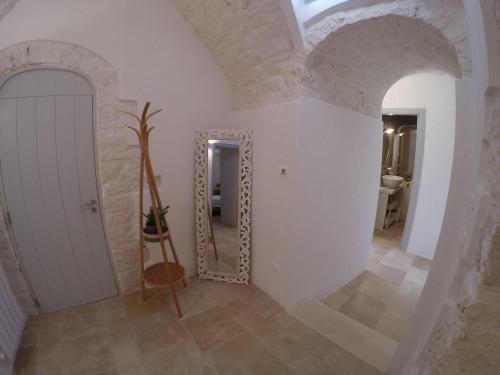 a hallway with a mirror in a room at TRULLI GIACI&MAURI in Selva di Fasano