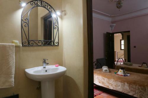 a bathroom with a sink and a mirror and a bed at Hotel Soleil Imlil in Imlil