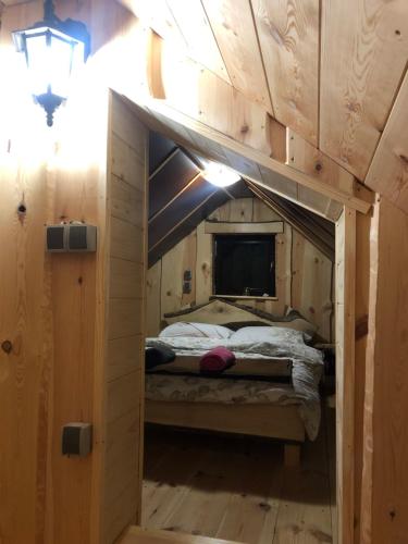 a small bedroom with a bed in a wooden cabin at Suška Koča in Stahovica