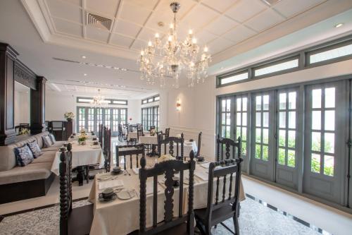 a dining room with tables and a chandelier at Souphattra Hotel Luang Prabang in Luang Prabang