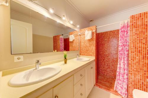 a bathroom with two sinks and a mirror at Beach Villa Pins by Sealand Villas in Cala de Sant Vicent