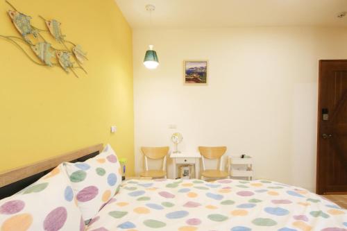 a bedroom with a bed and a table with chairs at The Wind BnB Ⅱ in Budai
