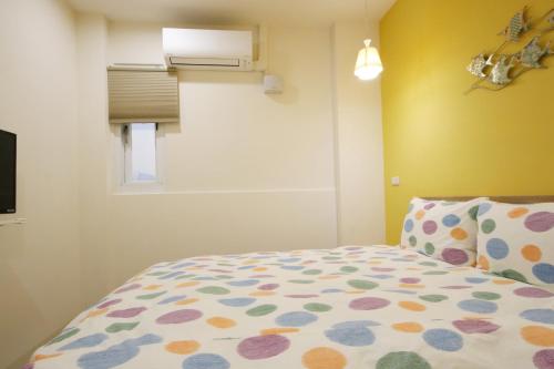 a bedroom with a bed with a polka dot bedspread at The Wind BnB Ⅱ in Budai