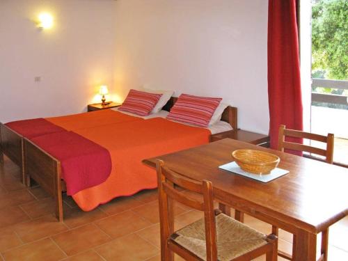 ポルト・ヴェッキオにあるRésidence Mari di Soliのベッドルーム1室(ベッド1台、テーブル、テーブル、椅子付)