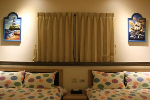 a bedroom with two beds and a window at The Wind BnB Ⅱ in Budai