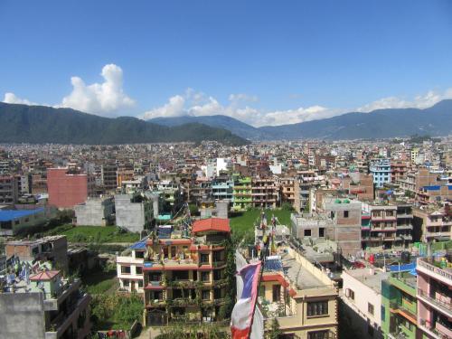 a city with buildings and mountains in the background at STUPA VIEW INN in Kathmandu