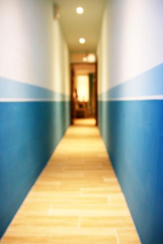 a hallway with blue and white walls and a wooden floor at The Wind BnB Ⅱ in Budai