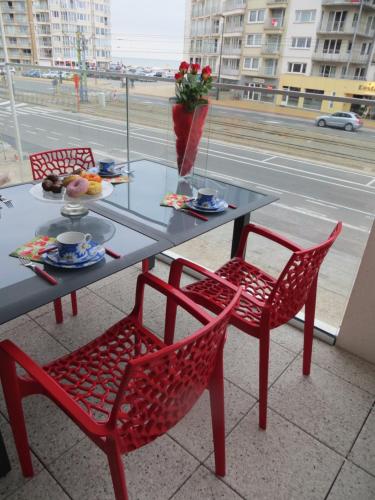a table with two chairs and a table with food on it at Osea Oostende in Ostend