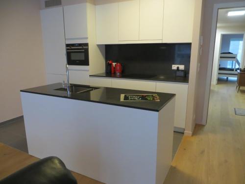 a kitchen with a black counter top and white cabinets at Osea Oostende in Ostend