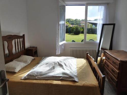 a bedroom with a bed with a dresser and a window at iguski in Boucau