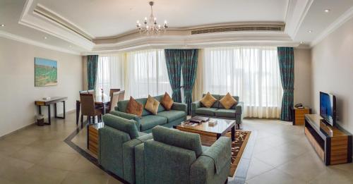a living room with two couches and a table at Al Majaz Premiere Hotel Apartments in Sharjah