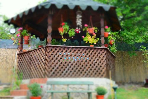 a wooden fence with a gazebo with flowers in it at Casa Smeilor Horezu in Horezu