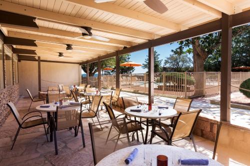 
a patio area with tables, chairs and umbrellas at Kayenta Monument Valley Inn in Kayenta
