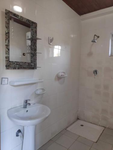 a white bathroom with a sink and a mirror at Merkeza Guest House in Lalībela