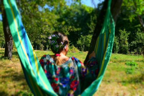 a woman is sitting in a hammock at Casa Smeilor Horezu in Horezu