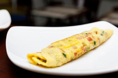 a burrito on a white plate on a table at Chez Mimosa Petite - Free Laundry in Ho Chi Minh City
