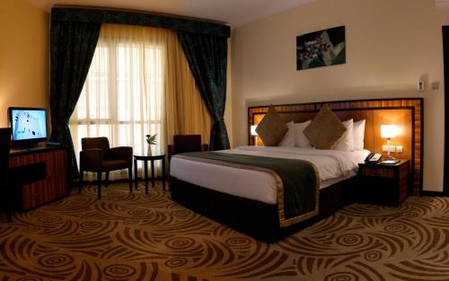a hotel room with a bed and a television at Al Majaz Premiere Hotel Apartments in Sharjah