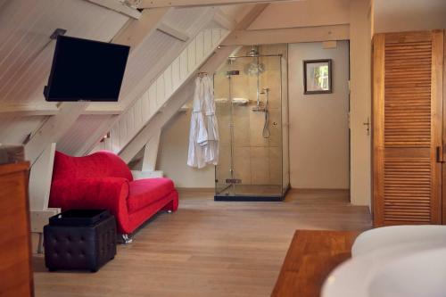 a living room with a red chair and a shower at Landgoed Groot Warnsborn in Arnhem