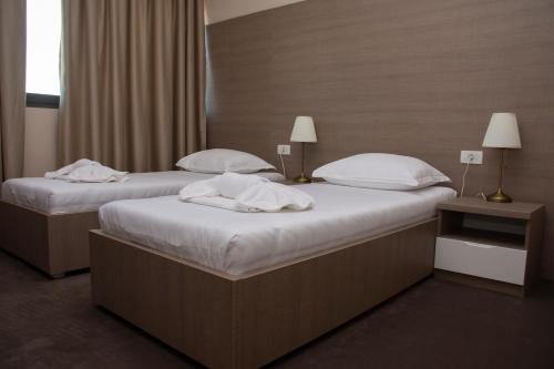two beds in a hotel room with towels on them at Hotel Narenta in Metković