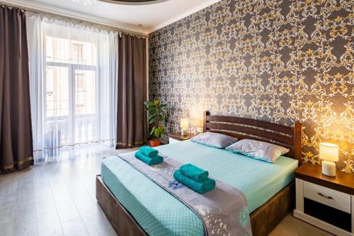 a bedroom with a bed with two green towels on it at Apartment with 2 bedroom near Opera House Gorodotska 27 str with parking in Lviv