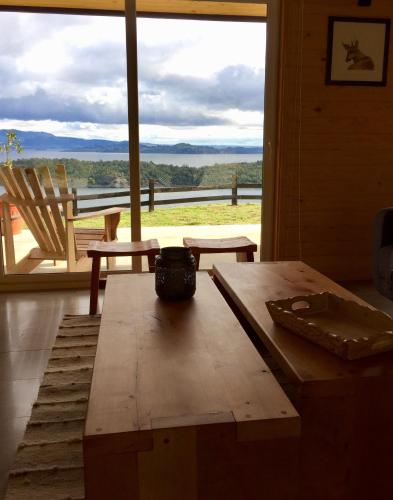 a room with a wooden table and a large window at Casa La Trafa in Futrono