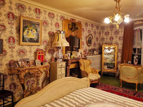 a bedroom with a bed and a room with wallpaper at Le Kino Panorama in Vic-sur-Cère