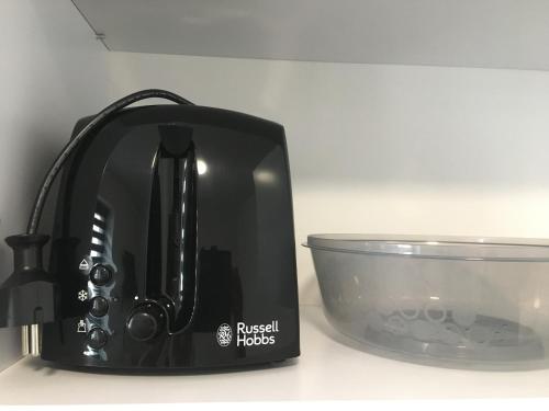 a black toaster next to a bowl on a counter at Studio Fibra Gusto in Rybnik