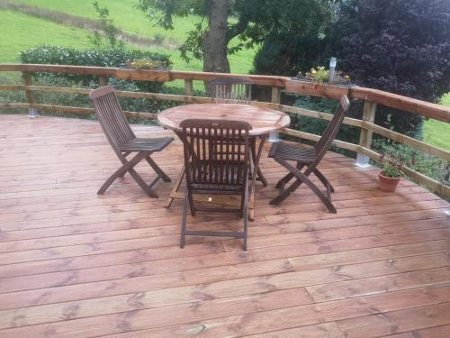 a wooden deck with a table and chairs on it at Le chalet de Roanne-Coo in Stoumont