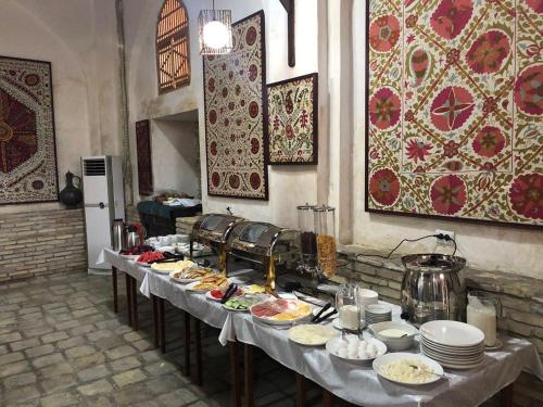 een buffettafel met borden eten erop bij Boutique Hotel Minzifa in Bukhara