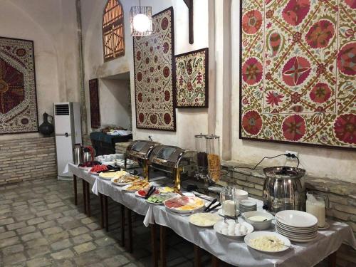 a table with plates of food on it at Boutique Hotel Minzifa in Bukhara
