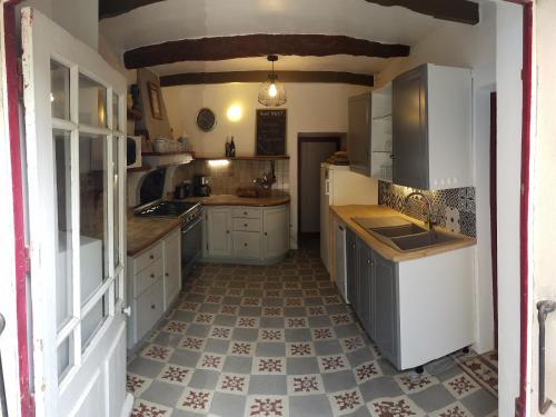 a kitchen with white cabinets and a tile floor at Mas de Regardebon in Mazan