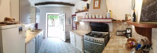 a kitchen with a stove and a refrigerator at Mas de Regardebon in Mazan