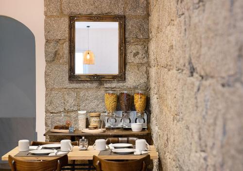 a dining room with a table with chairs and a mirror at Holzer II in Porto-Vecchio
