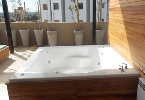 a large white bath tub in a bathroom at Nandó Apart Hotel in Cipolletti
