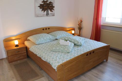 ein Schlafzimmer mit einem Holzbett mit zwei Kissen in der Unterkunft Ferienhof Schaubmeier in Klaffer am Hochficht