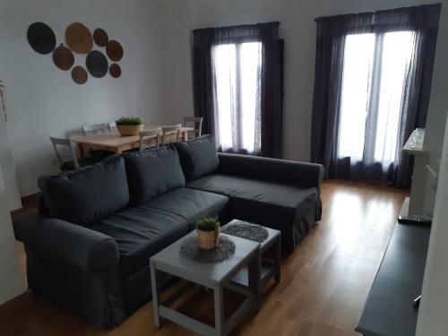 a living room with a black couch and a table at Alojamiento La Fuente in Fuenteheridos