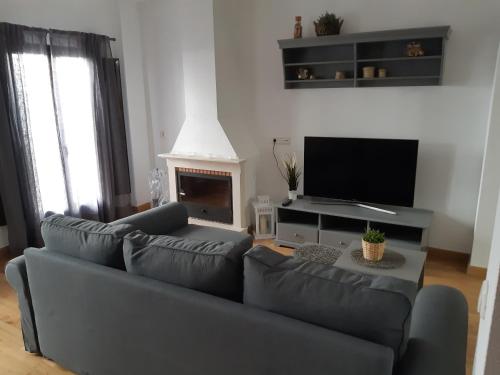 a living room with a couch and a television at Alojamiento La Fuente in Fuenteheridos