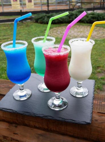 a group of four different colored drinks on a tray at Western-Inn in Klipphausen