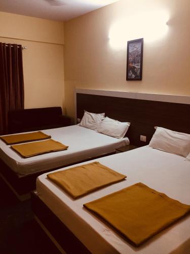 two beds in a hotel room with towels on them at Sapphire Inn in Bangalore