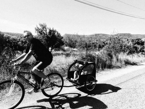 ClaretにあるUn nid entre vignes et pierres "Pic St Loup"の赤ちゃん車を持つ自転車に乗る男