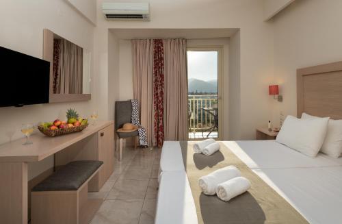 a hotel room with a large bed and a balcony at CHC Marilena Hotel in Amoudara Herakliou