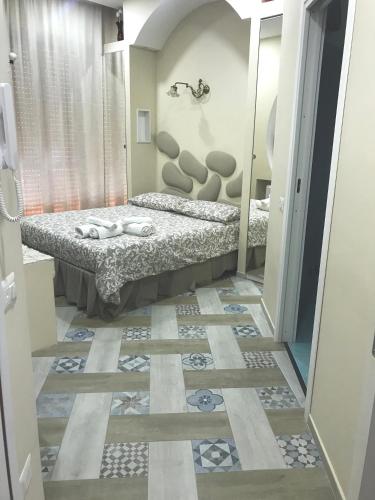 a bedroom with a bed and a tile floor at Vesuvio Rooms in Gragnano