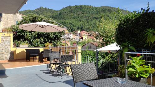 a patio with tables and chairs and an umbrella at Pietra Di Mare in Biassa