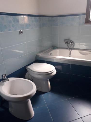 a bathroom with a toilet and a bath tub at Ypsibloom in Castelbuono