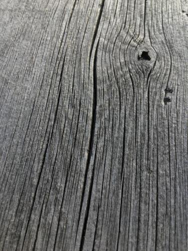 a close up of a wooden table with lines in it at Lofoten Fjord Lodge in Saupstad