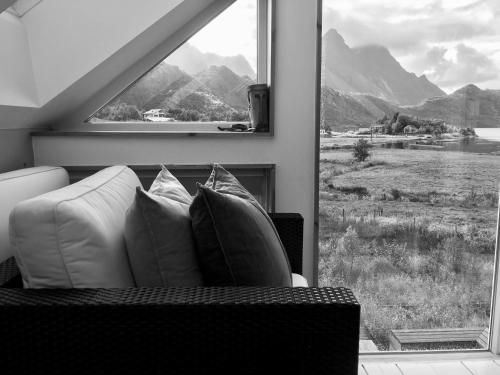 a living room with a couch and a large window at Lofoten Fjord Lodge in Saupstad