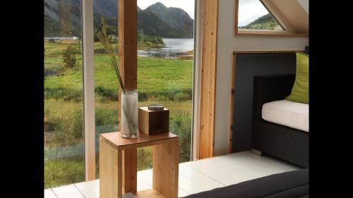 a vase sitting on a table in front of a window at Lofoten Fjord Lodge in Saupstad