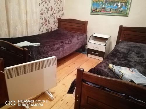a small bedroom with two beds and a fan at Nora's guesthouse in Zhabeshi