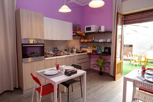 uma cozinha com paredes roxas e uma mesa e cadeiras em B&B Fiori di Lava em Nicolosi