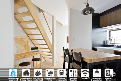 a kitchen with a table and chairs and a staircase at Vacation House Tennoji 168 IROHA, Osaka in Osaka